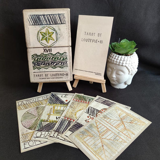 Tarot de Louttre B Grimaud de 1981 avec sa boîte d’origine, sa notice explicative et plusieurs cartes étalées.
